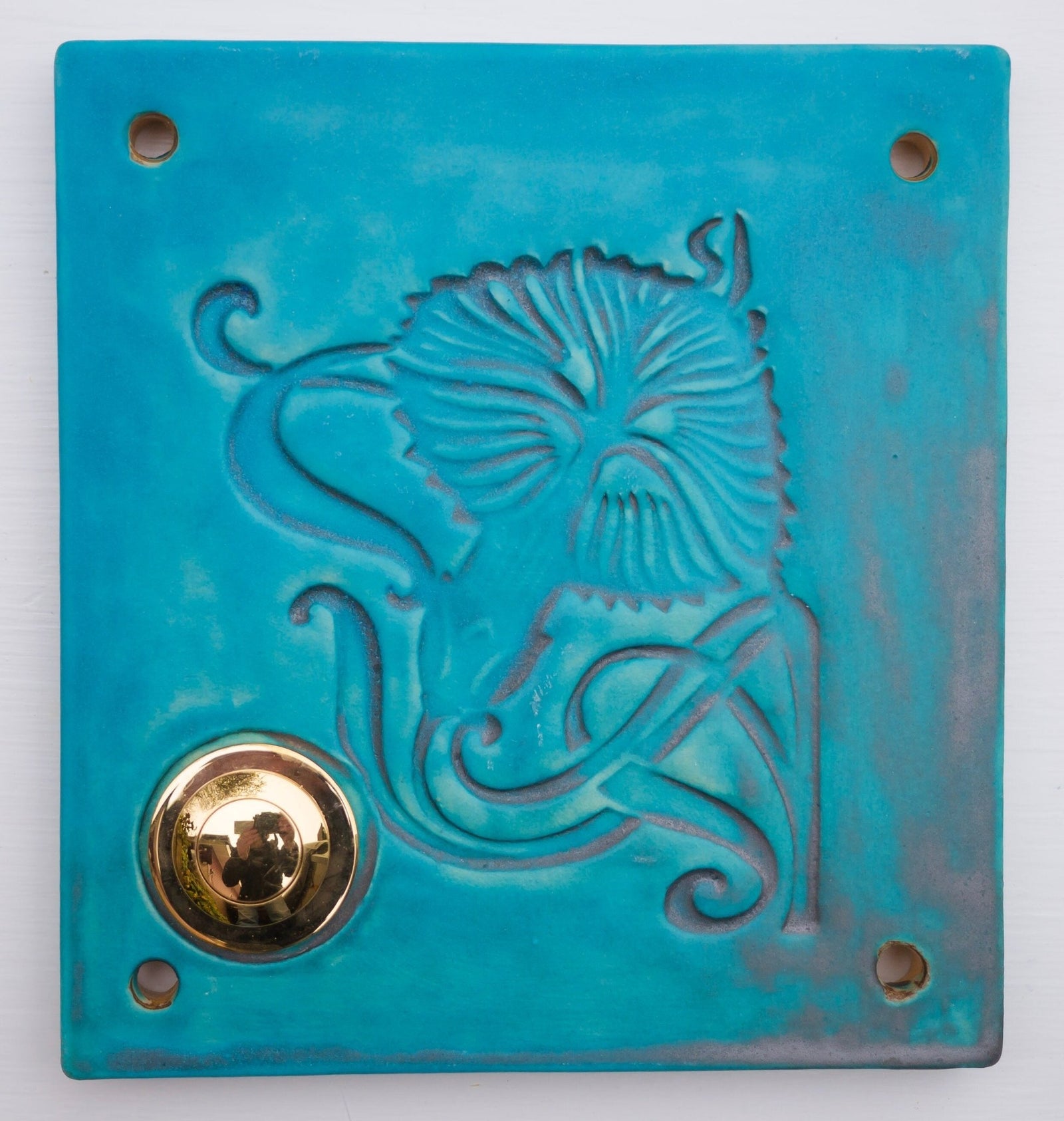 Eckige weiße Keramik-Klingelplatte mit floralem Muster und goldenem Knopf.