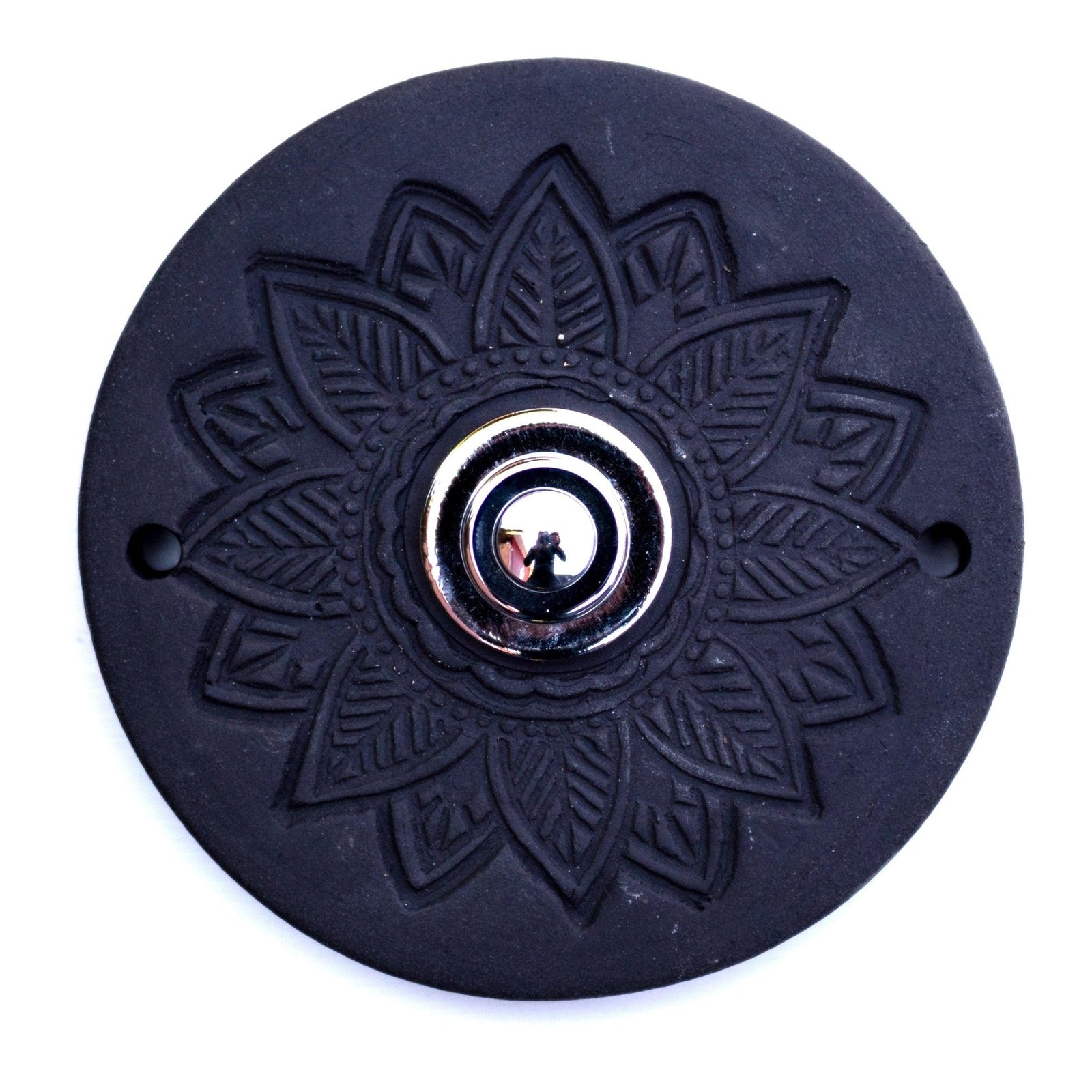 Runde dekorative Klingel mit geprägtem Mandala-Blumenmuster auf schwarzer Platte und silbernem Druckknopf in der Mitte