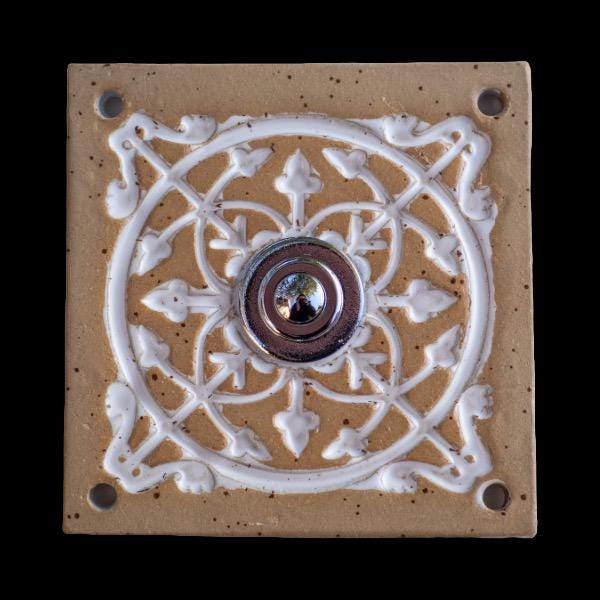 Handgefertigte Keramikklingel in Naturbeige mit dekorativem weißen Reliefmuster und silbernem Knopf. Der elegante Kontrast der hellen Töne verleiht Ihrem Eingangsbereich eine edle und einladende Note.