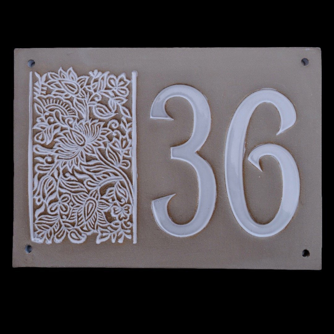 Rechteckiges graues Keramik-Hausschild mit erhabenen weißen Ziffern 36 und floralem Dekor