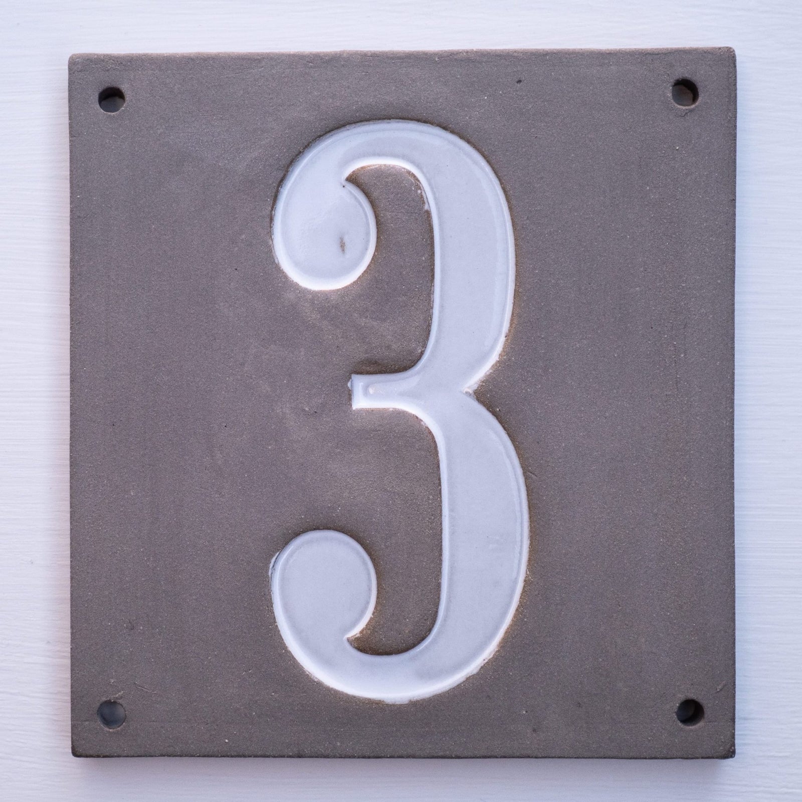 Rechteckiges graues Keramik-Hausschild mit erhabenen weißen Ziffern 3