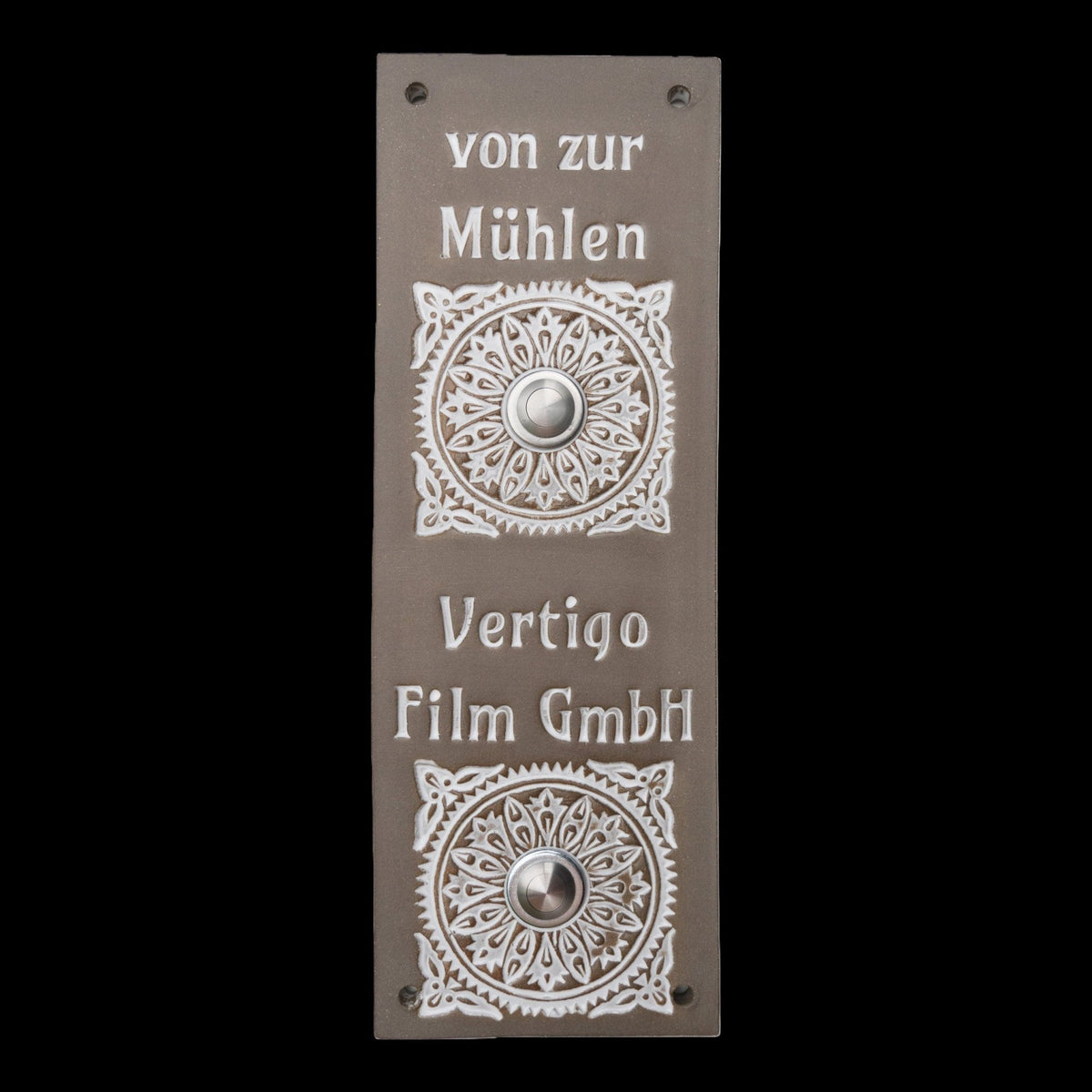 Rechteckige graue Keramik-Klingelplatte mit zwei silbernen Knöpfen, verziert mit Blumenornamenten und den eingravierten Namen 'von zur Mühlen' und 'Vertigo Film GmbH