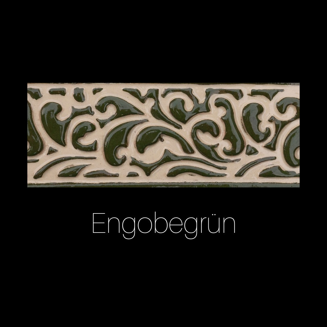 Handgefertigte Keramikfliese mit Blumen- und Rankenrelief, ausgefüllt mit glänzendem rotem Engobe auf cremeweißer Oberfläche. Dekorativ und ornamental