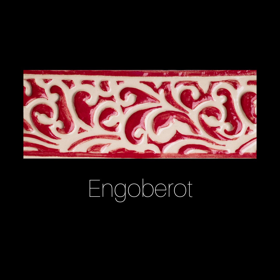 Handgefertigte Keramikfliese mit Blumen- und Rankenrelief, ausgefüllt mit glänzendem rotem Engobe auf cremeweißer Oberfläche. Dekorativ und ornamental