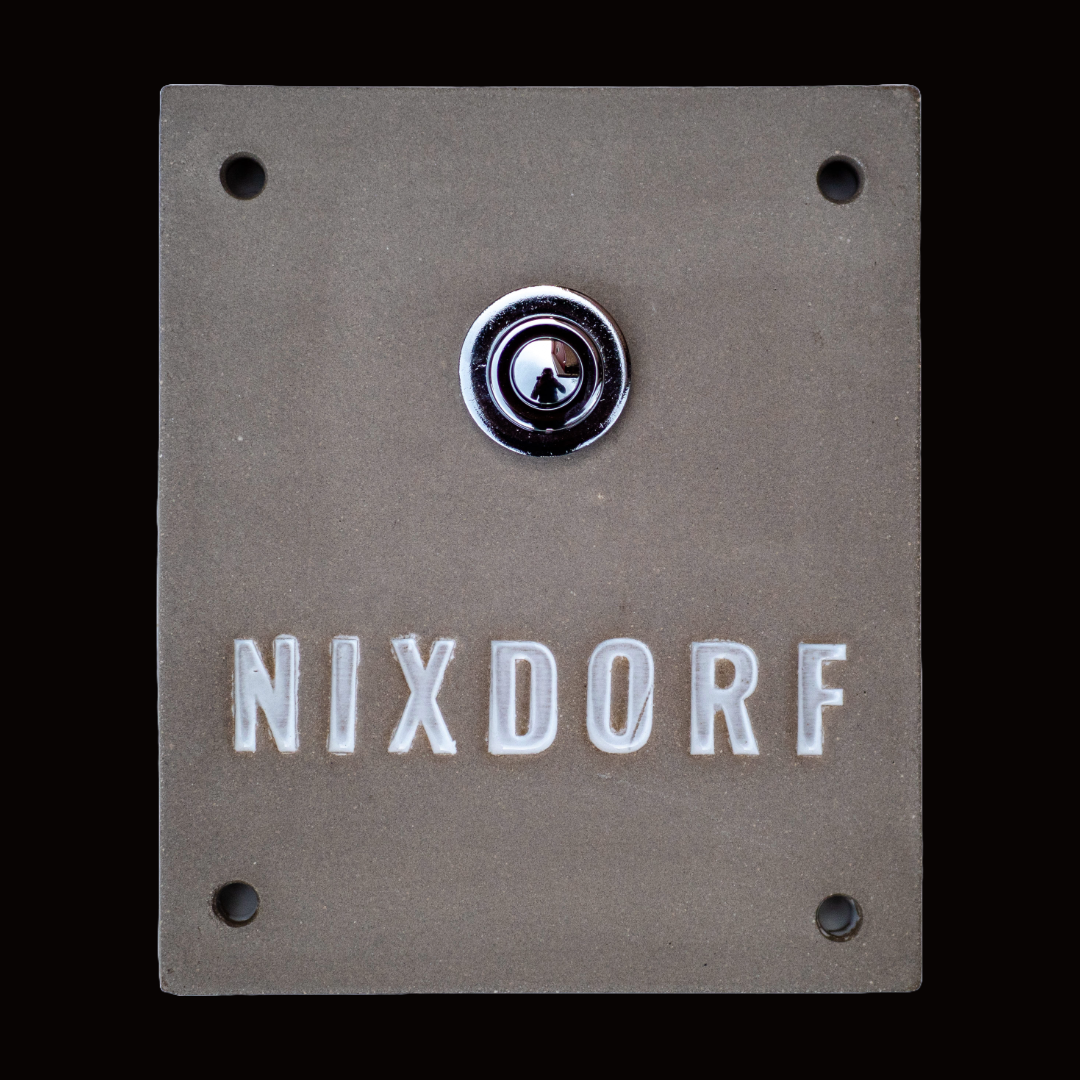 Handgefertigte Keramik-Türklingel in Beige mit silbernem Klingelknopf. Der Name Nixdorf ist in weißer Schrift eingraviert und verleiht dem Eingangsbereich eine elegante, persönliche Note.