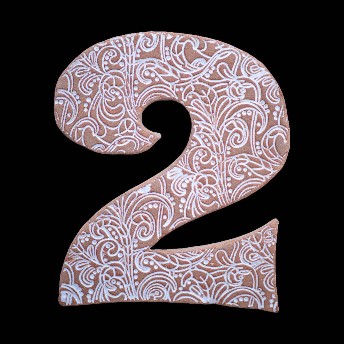 Handgefertigte Keramik-Hausnummer „2“ in Naturbraun mit weißen geprägten Ornamentmustern, vor schwarzem Hintergrund dargestellt.