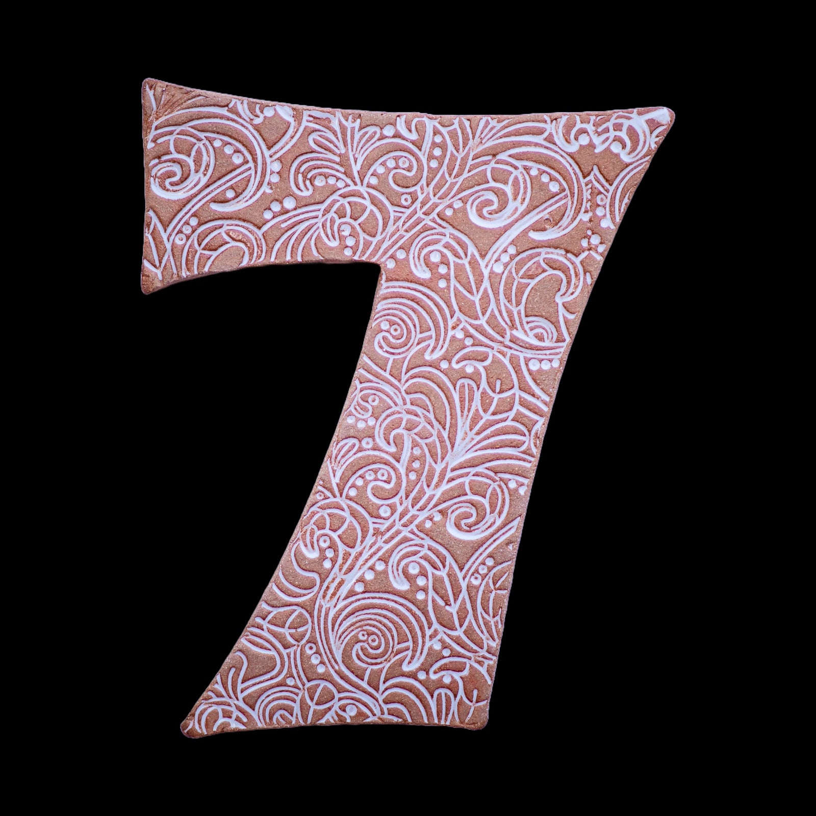 Handgefertigte Keramik-Hausnummer „7“ mit kunstvollem weißen Muster auf terrakottafarbenem Hintergrund.