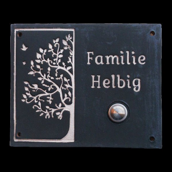 Schwarze Keramik-Klingelplatte mit silberner Baumgravur, Aufschrift 'Familie Helbig' und rundem Metallknopf."
