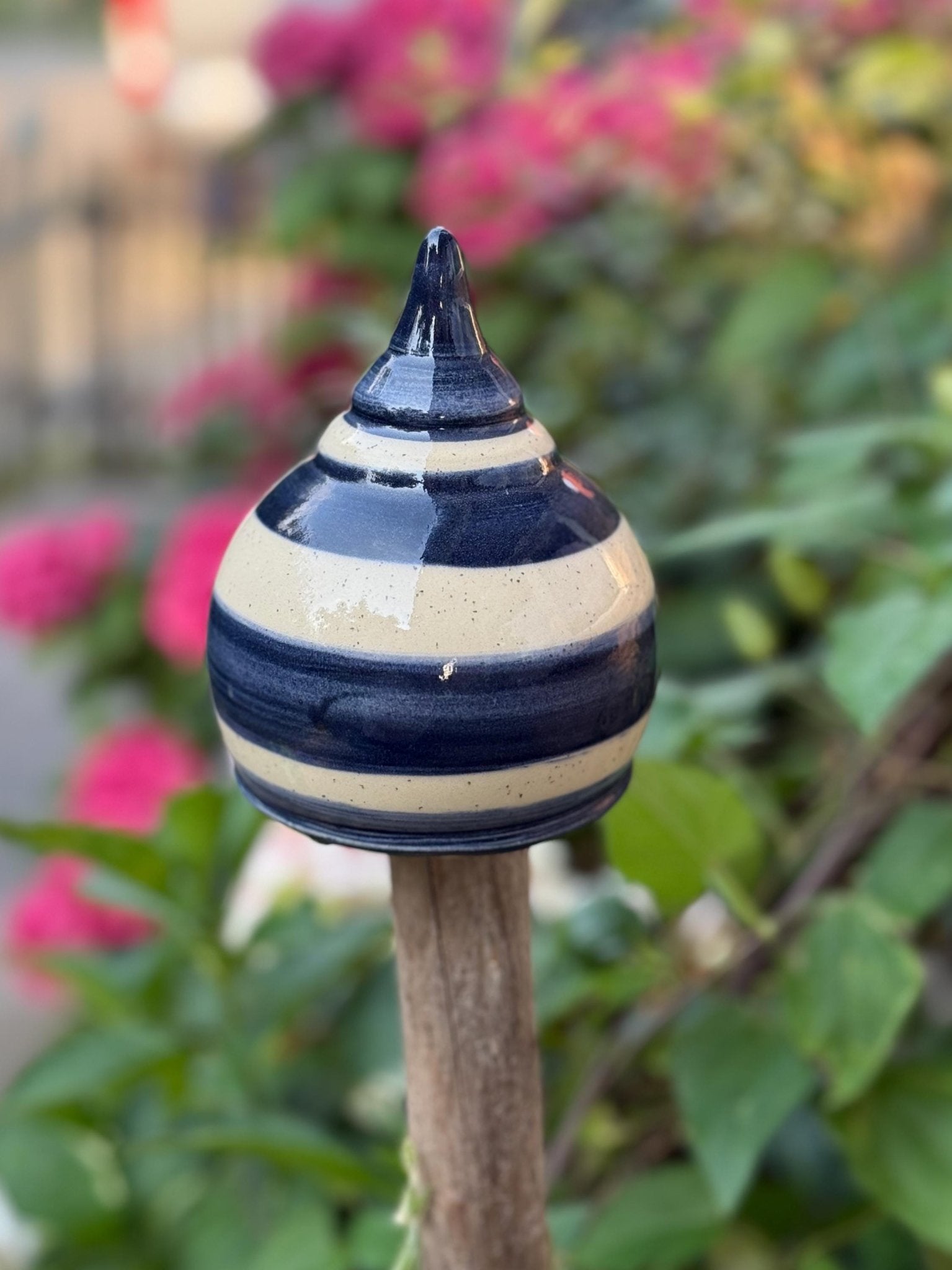 Handgefertigte Keramik-Gartenkugel mit blauen und cremefarbenen Streifen. Ideal als dekorativer Aufsatz für Gartenstäbe und Zäune.