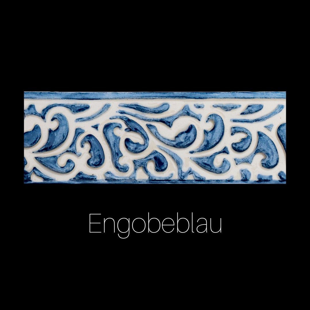 Handgefertigte Keramikfliese mit Blumen- und Rankenrelief, ausgefüllt mit glänzendem rotem Engobe auf cremeweißer Oberfläche. Dekorativ und ornamental