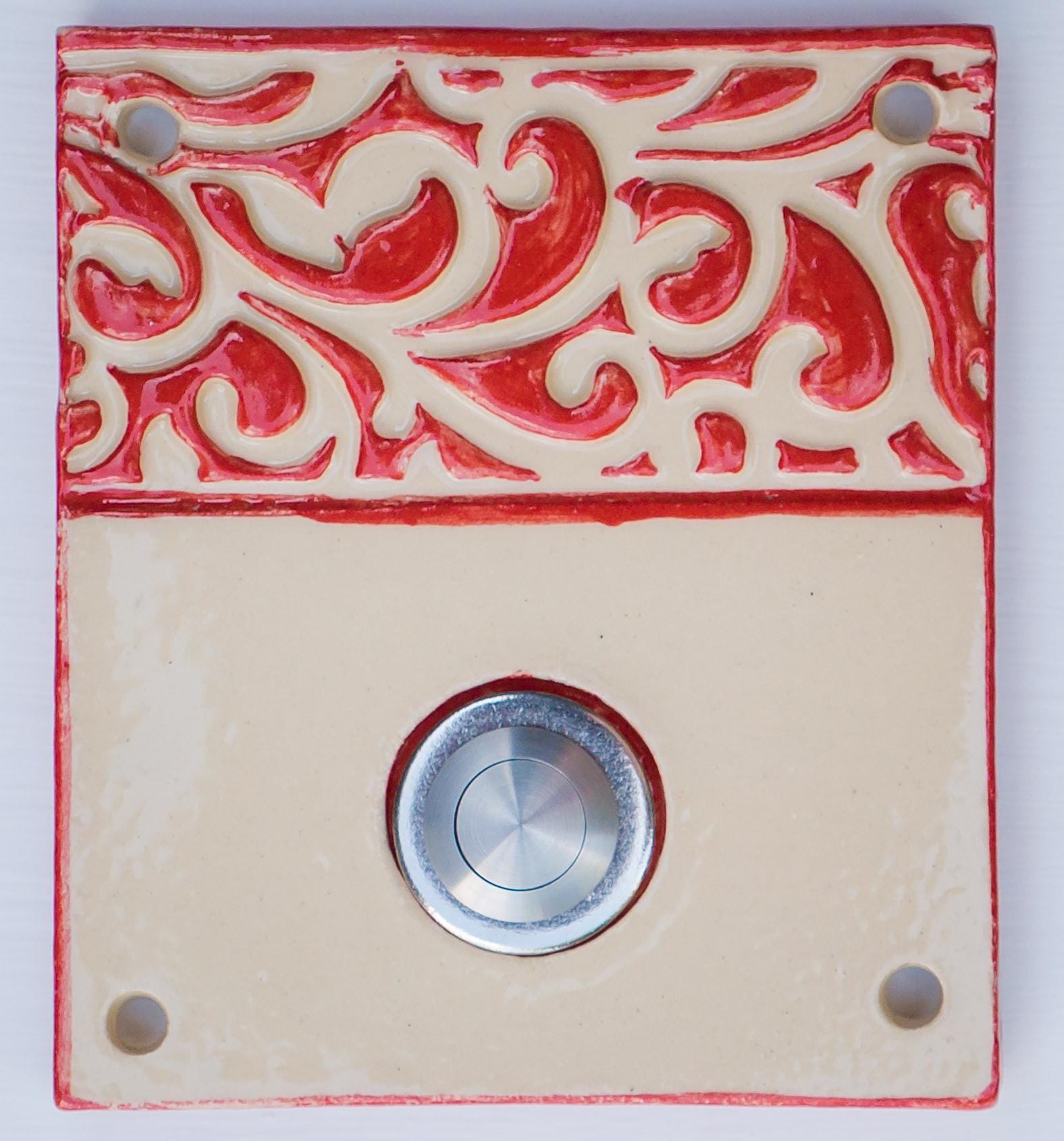 Handgefertigte beige Keramiktürklingel mit dekorativem rotem Reliefband und Edelstahlknopf. Ein ausdrucksstarkes Design, das Langlebigkeit, Eleganz und Individualität für Ihren Eingangsbereich vereint.