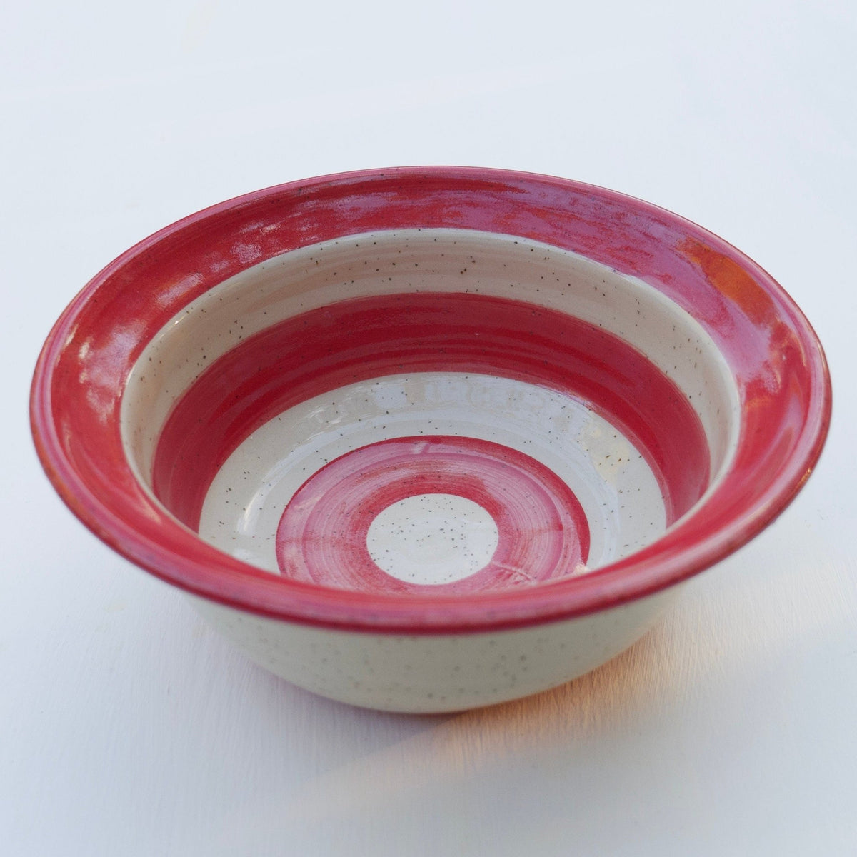 Handgefertigte Keramikschale mit rot-weißer Glasur im Streifenmuster – rustikale Töpferei Servierschale