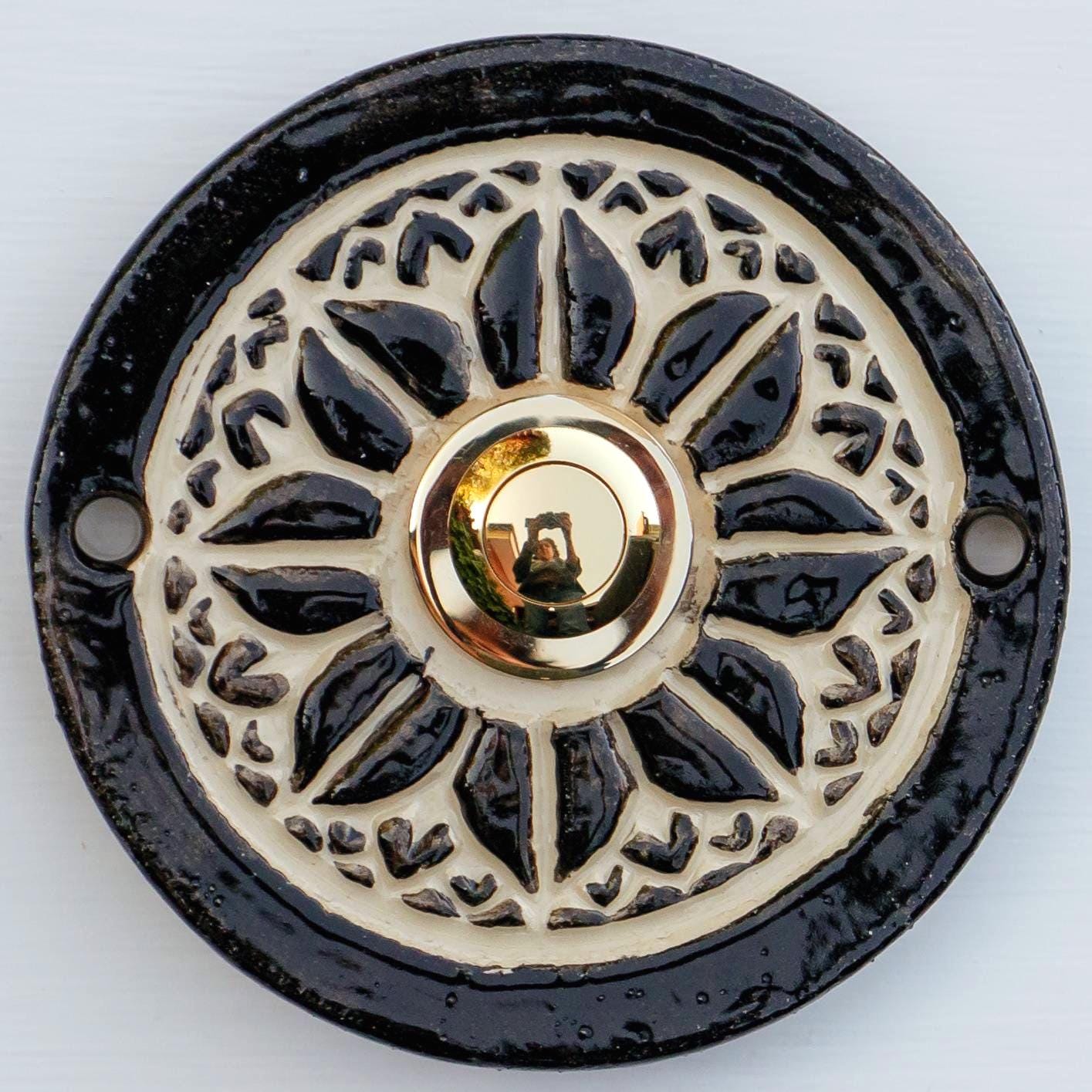 Stilvolle schwarze Keramiktürklingel mit kunstvollem Reliefmuster und Edelstahlknopf. Handgefertigt, robust und wetterfest.