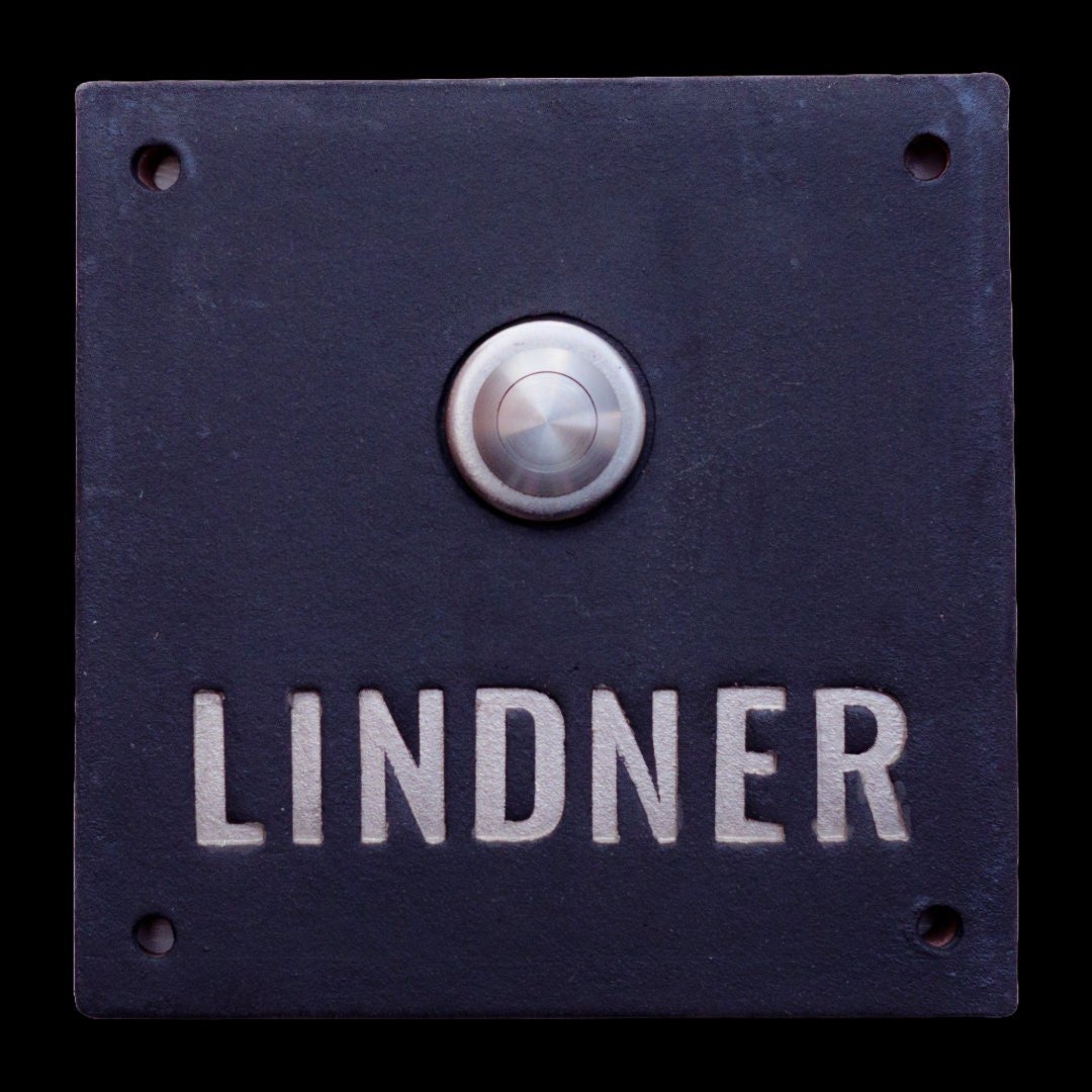 Handgefertigtes schwarzes Keramik-Klingelschild mit silberner Gravur „LINDNER“ und rundem Edelstahl-Klingelknopf, ca. 12×12 cm