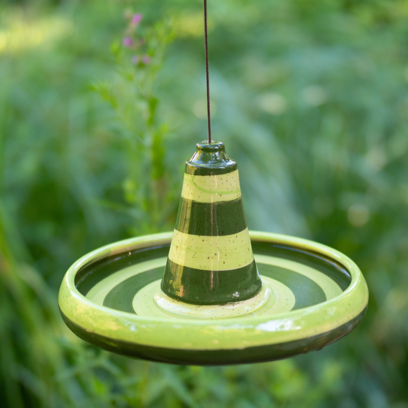 Handgefertigte hängende Keramik-Vogeltränke oder Futterschale mit grünem Streifendesign. Wetterbeständig und ideal für Garten, Balkon oder Terrasse.