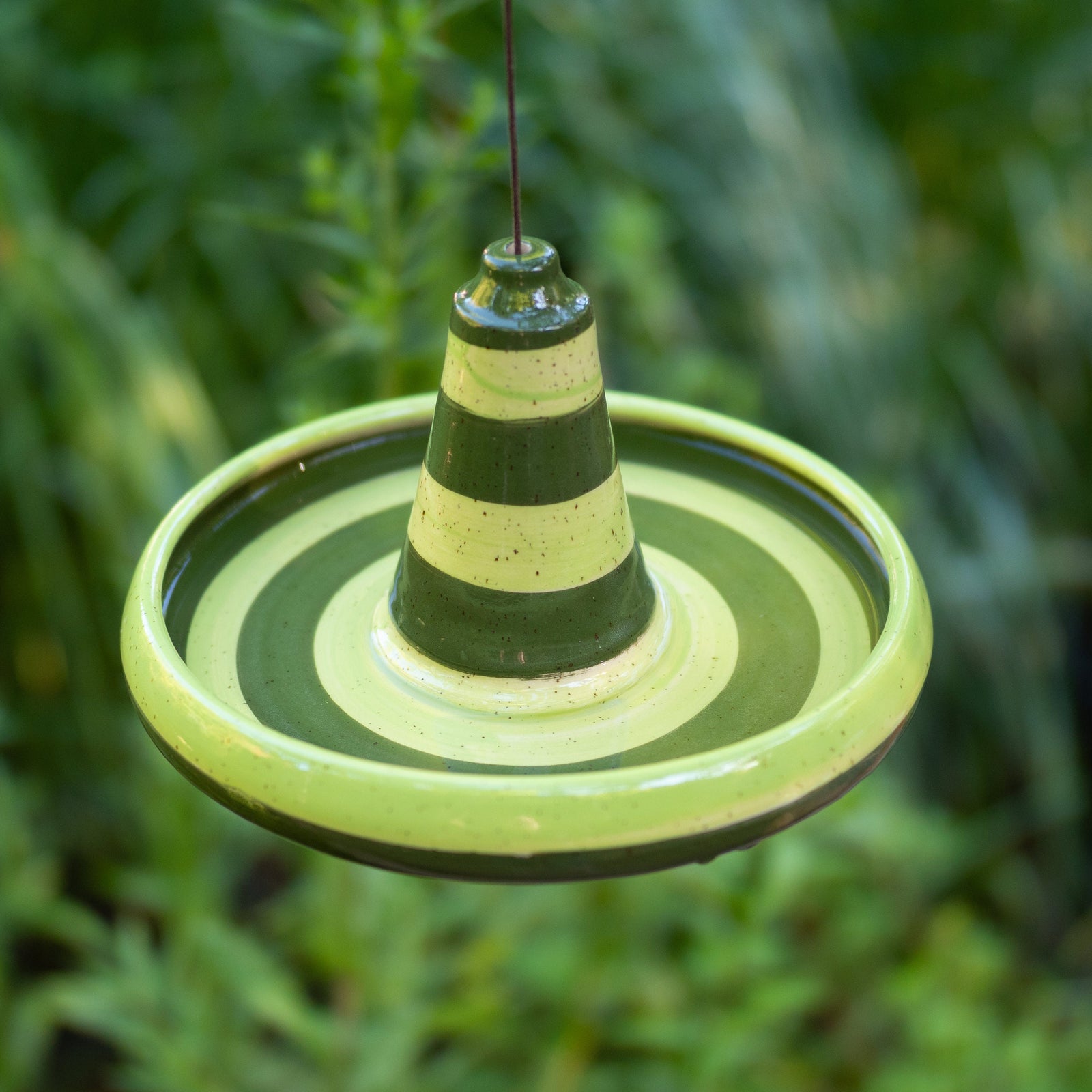 Handgefertigte hängende Keramik-Vogeltränke oder Futterschale mit grünem Streifendesign. Wetterbeständig und ideal für Garten, Balkon oder Terrasse.