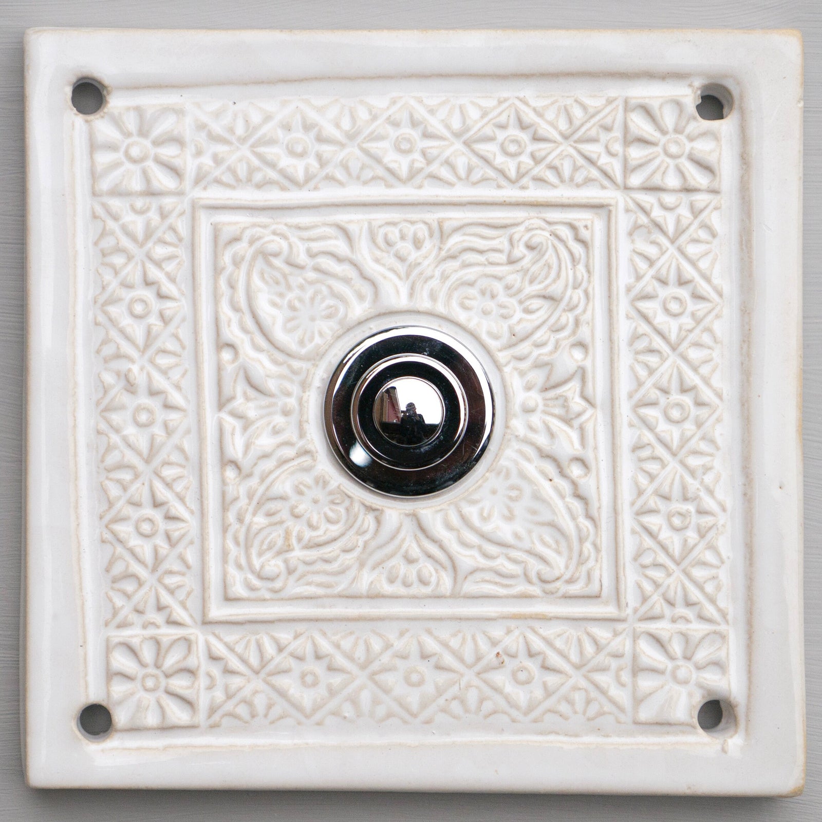 Quadratische weiße Keramik-Klingelplatte mit kunstvollem geprägtem Blumenmuster und poliertem Chromknopf