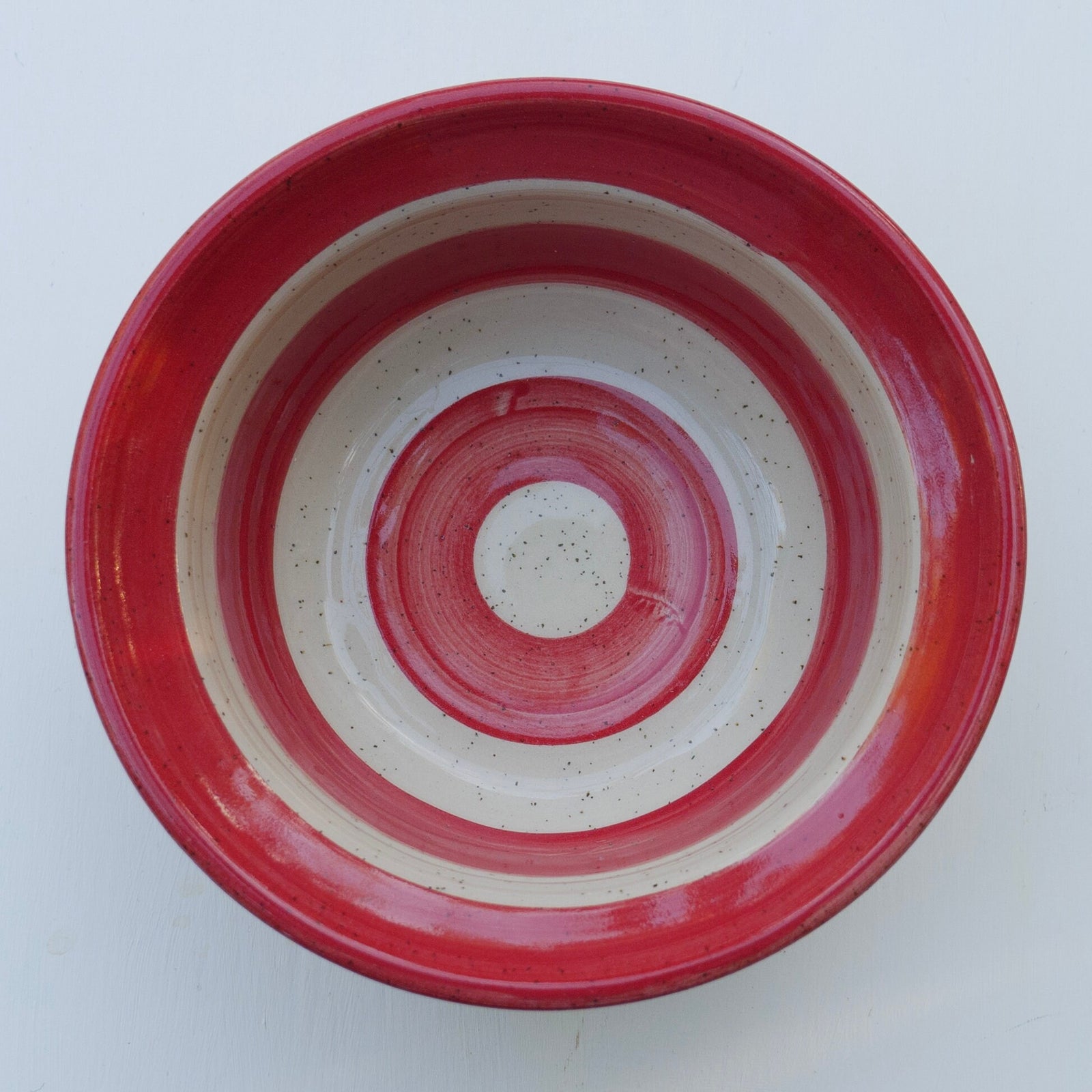 Handgefertigte Keramikschale mit rot-weißer Glasur im Streifenmuster – rustikale Töpferei Servierschale