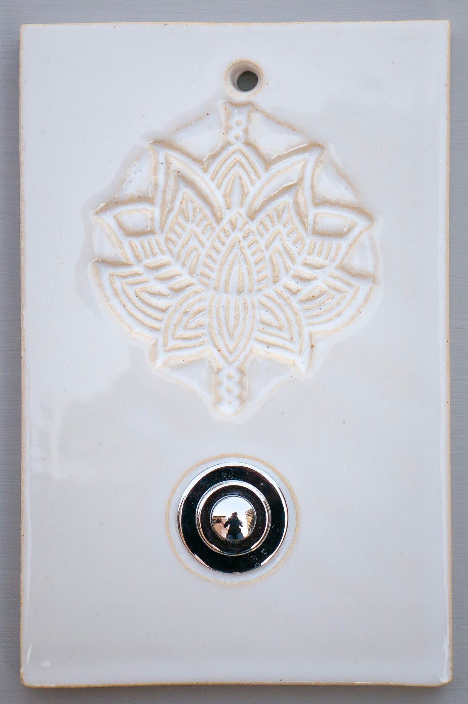 Rechteckige Keramik-Klingelplatte mit geprägtem Lotus-Blumenmuster und poliertem Chromknopf