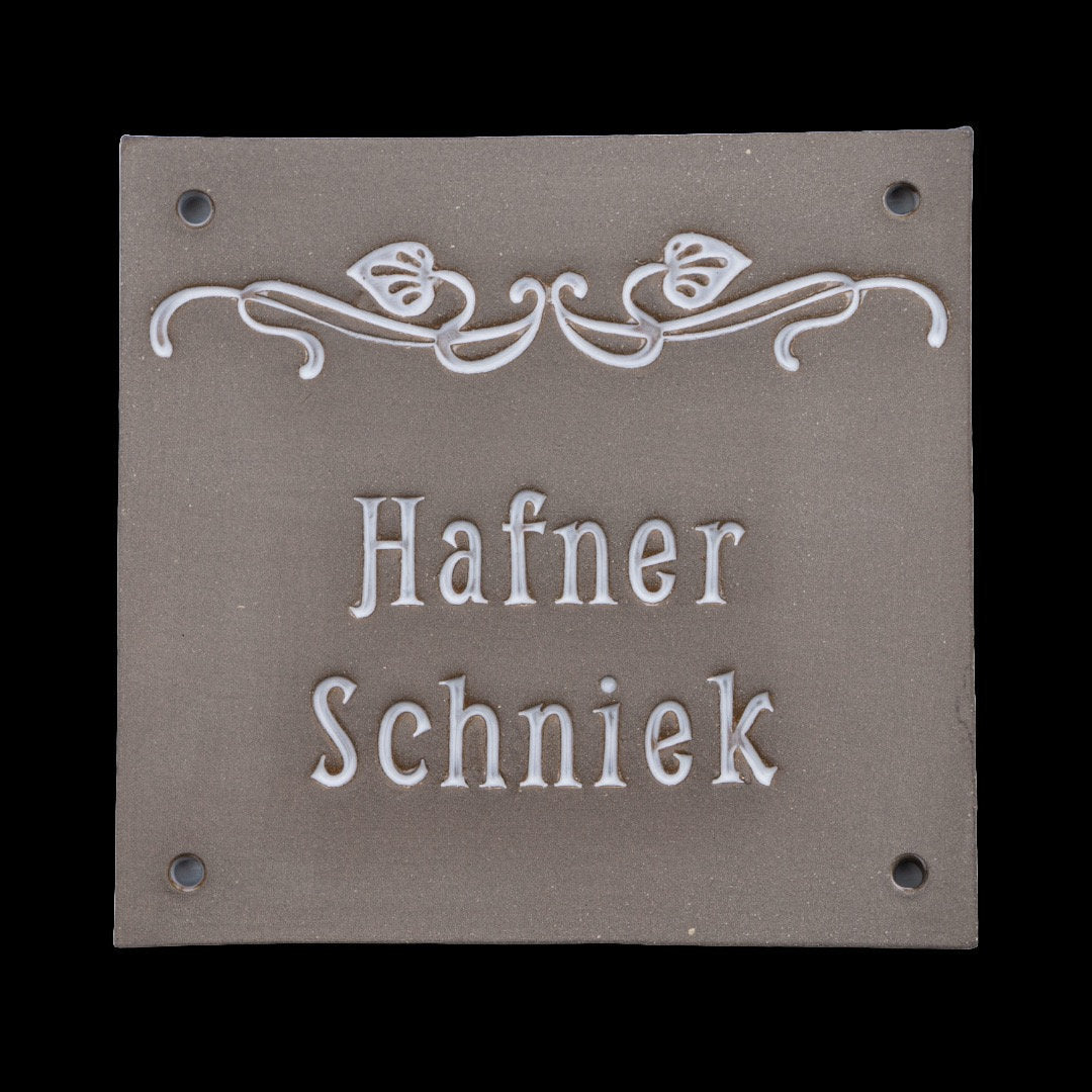 Eckiges Keramik-Türschild in Grau mit floralem weißen Relief und eingraviertem Namen Hafner Schniek