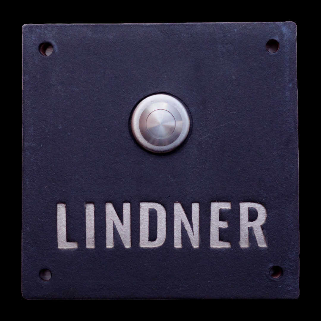 Handgefertigtes schwarzes Keramik-Klingelschild mit silberner Gravur „LINDNER“ und rundem Edelstahl-Klingelknopf, ca. 12×12 cm