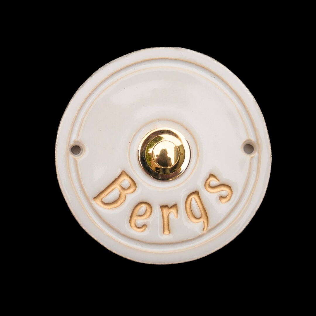 Runde weiße Keramik-Klingel mit goldenem Knopf und eingraviertem Text Bergs