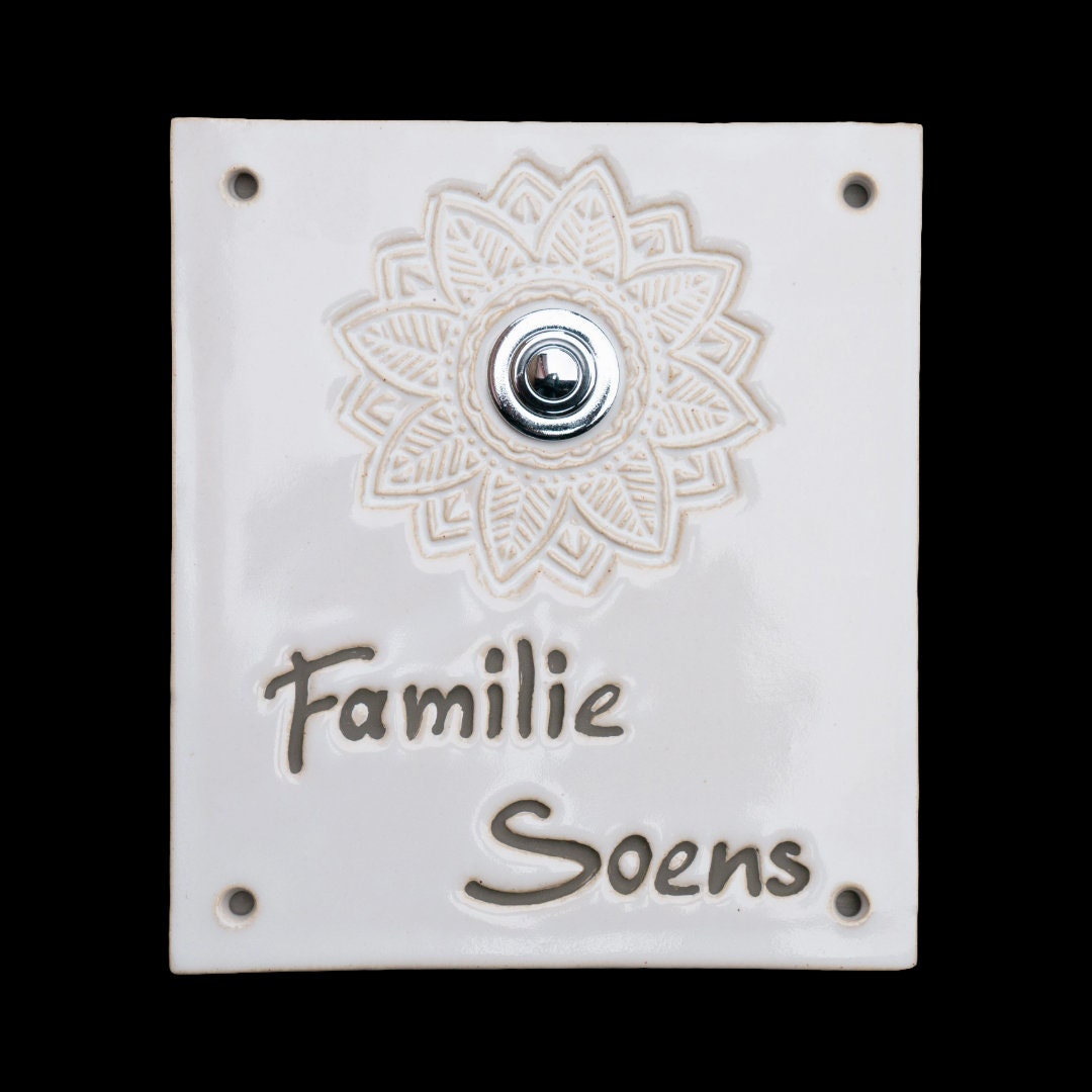 Quadratische weiße Keramiktürklingelplatte mit brauner Gravur 'Familie Soens' unter einem floralen Mandala-Design mit silbernem Knopf in der Mitte