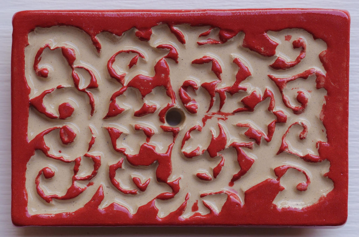 Rechteckige Keramik-Klingelplatte mit beigem Hintergrund und rotem Ornamentmuster in Blumenform