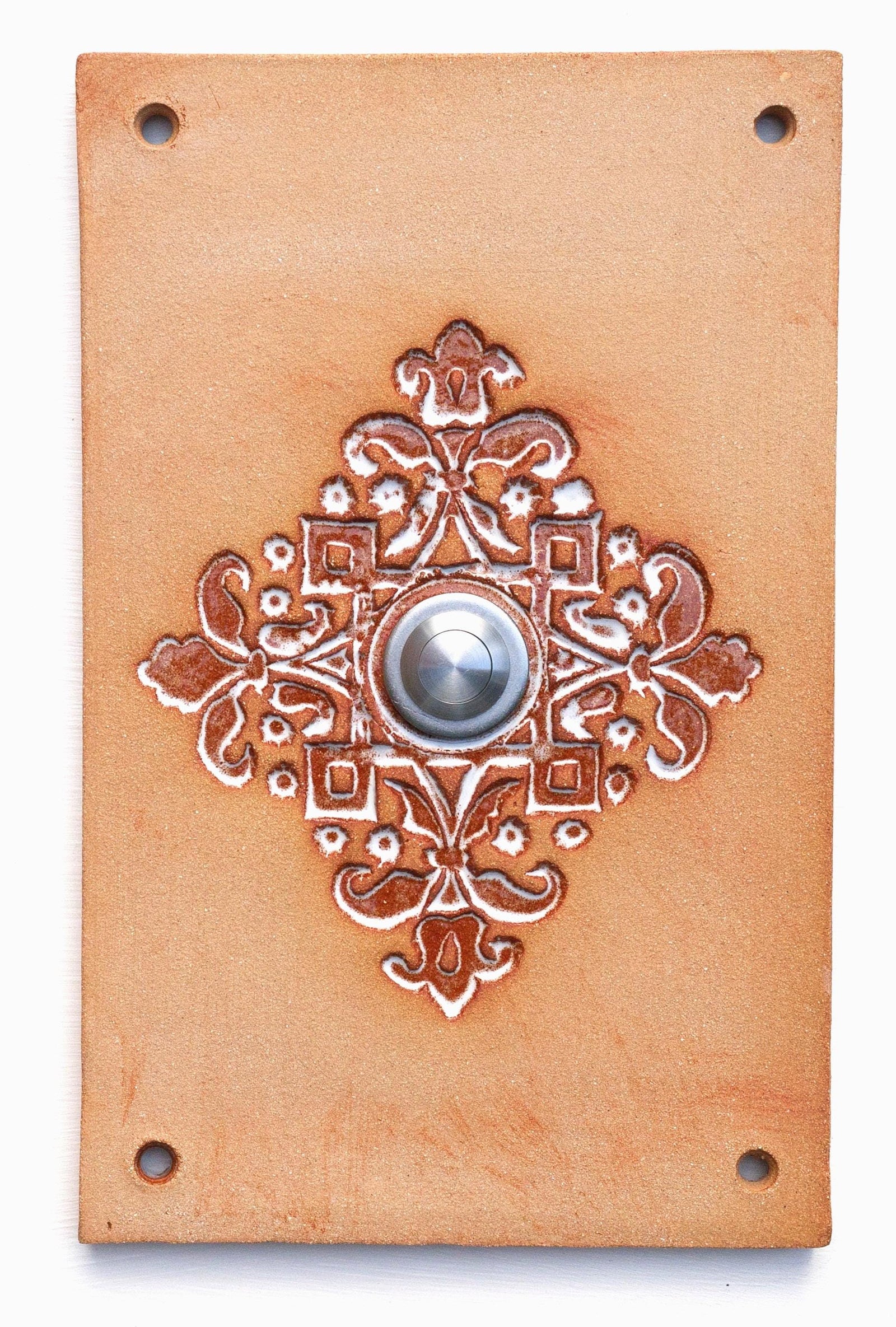 Rechteckige keramische Klingelplatte in Terrakottafarbe mit ornamentaler Prägung in Blumenmotiven und mittigem Silberknopf