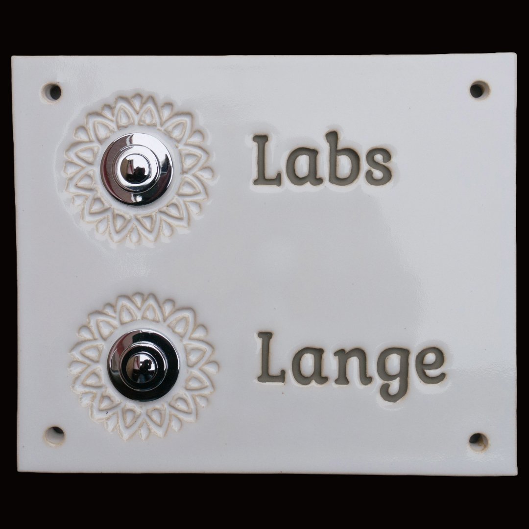 Weiße Keramik-Klingelplatte mit zwei silbernen Knöpfen, verziert mit Blumenmustern und den eingravierten Namen &#39;Labs&#39; und &#39;Lange