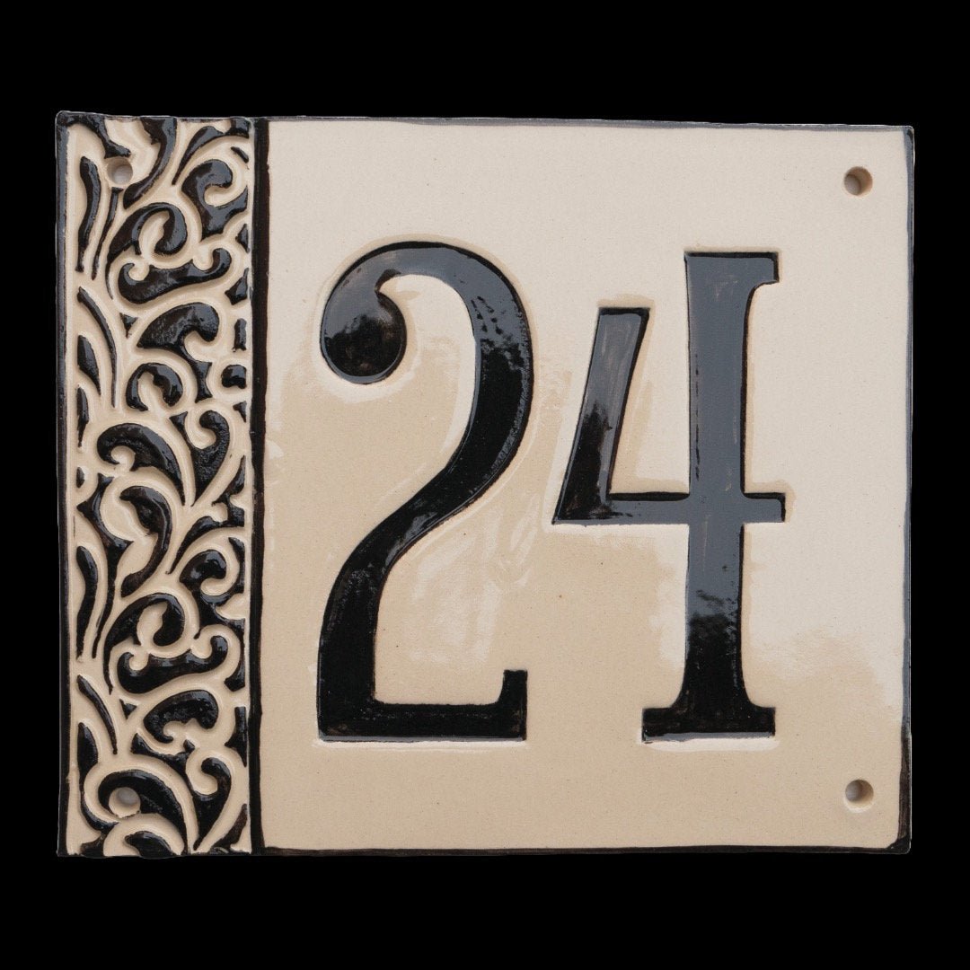 Beiges Keramik-Hausschild mit glänzenden schwarzen Ziffern 24 und dekorativem floralem Rand auf der linken Seite