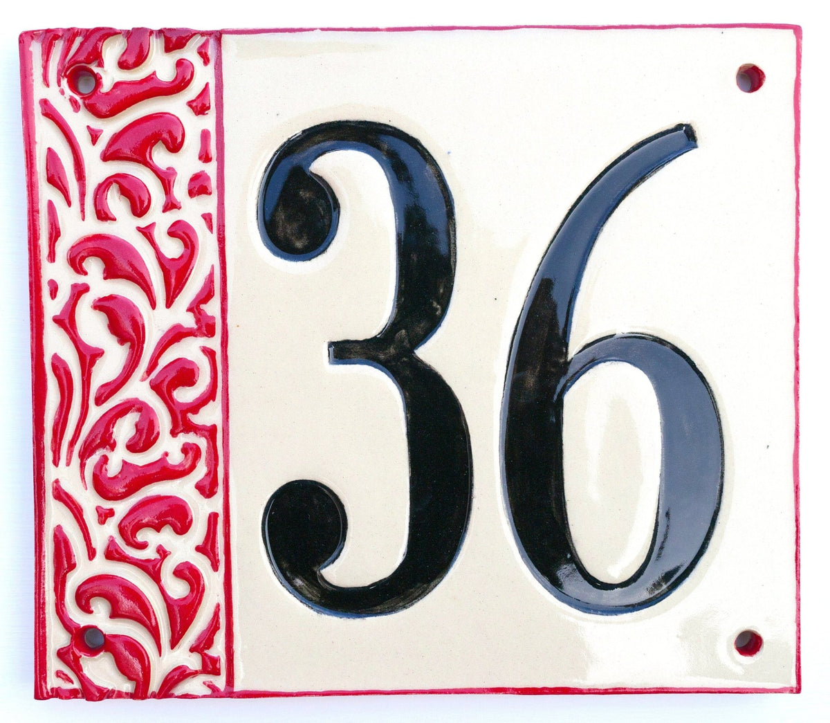 Rechteckiges Keramik-Hausschild mit cremefarbenem Hintergrund, glänzenden schwarzen Reliefziffern 36 und erhabenem roten Ziermuster am linken Rand