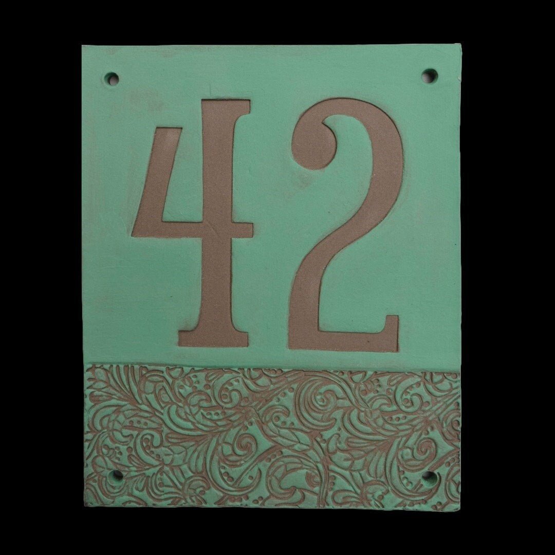 Rechteckiges Keramik-Hausschild mit mattem grünem Hintergrund, eingravierten tonfarbenen Ziffern 42 und dekorativem Blumenmuster im unteren Bereich