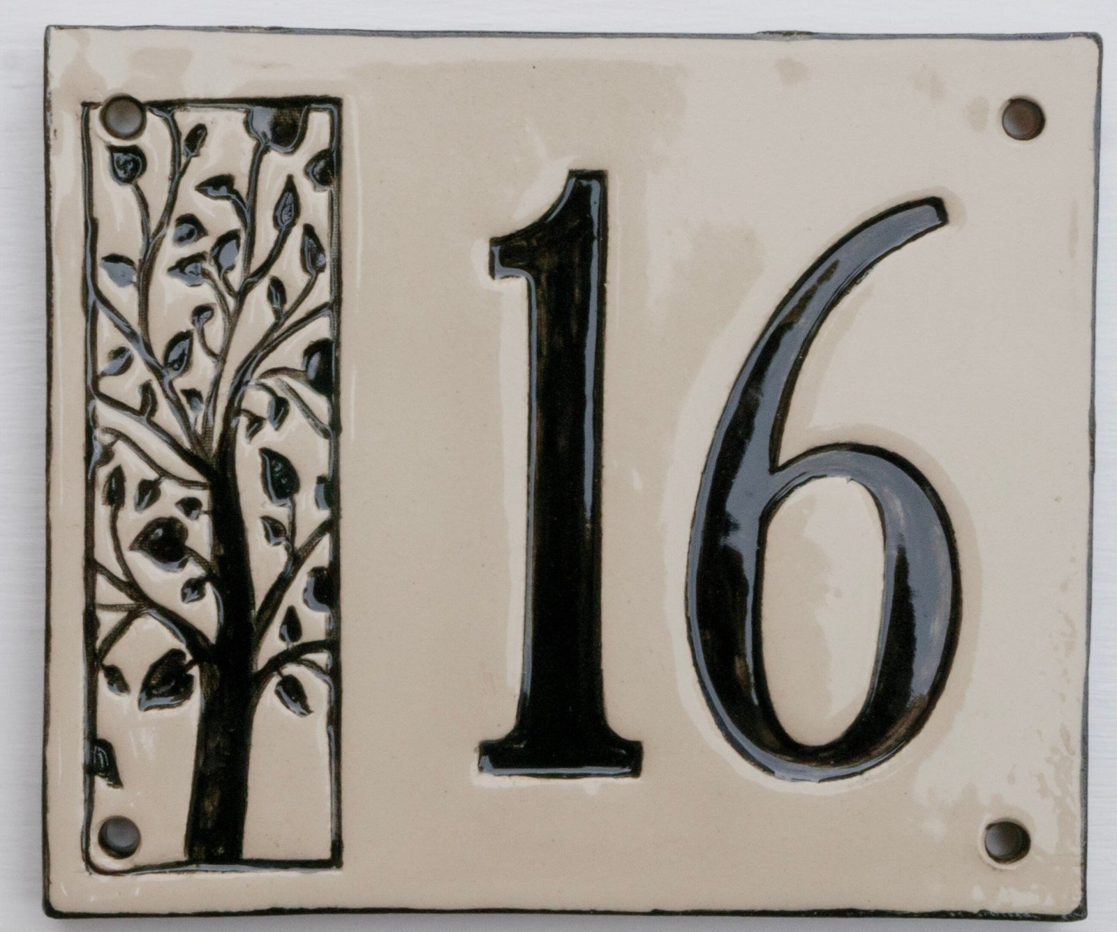 Handgefertigte Keramik-Hausnummerntafel mit schwarzer Zahl 16 und dekorativem Baumdesign auf cremefarbenem Hintergrund