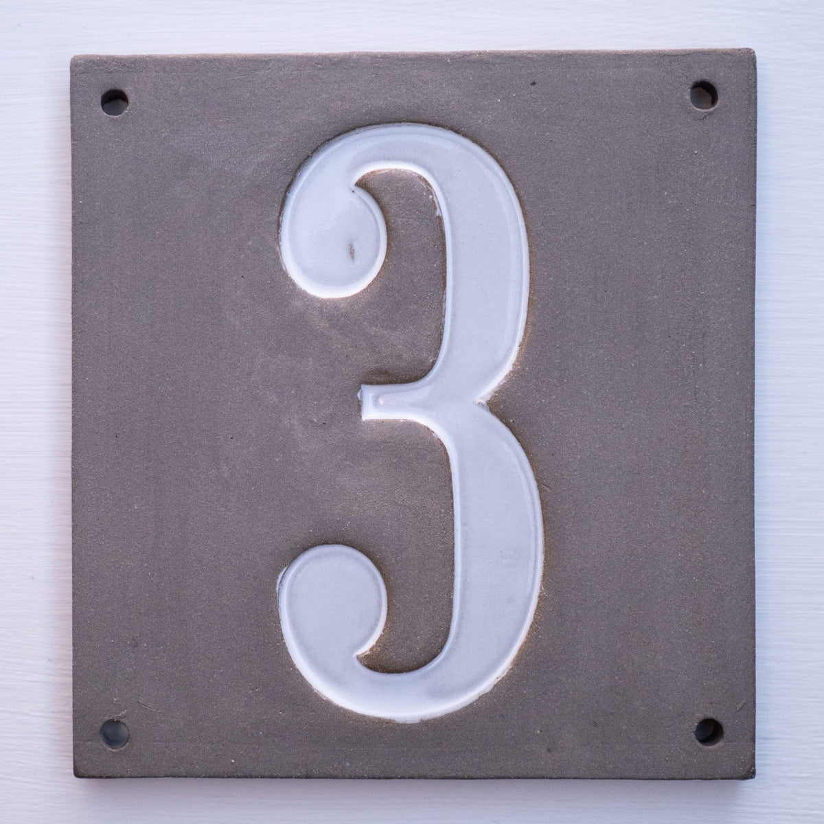 Rechteckiges graues Keramik-Hausschild mit erhabenen weißen Ziffern 3