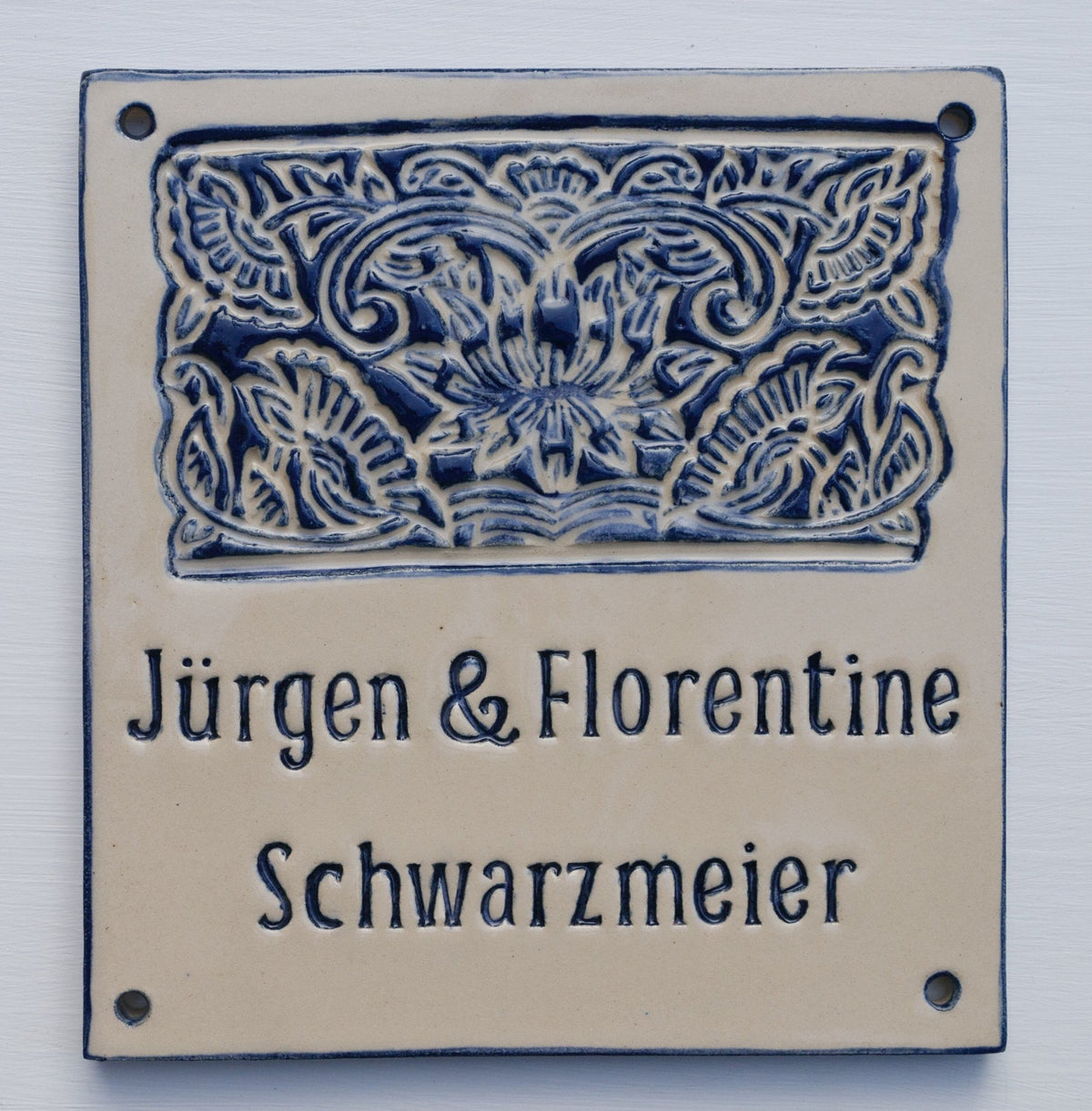 Beiges Keramik-Türschild mit dunkelblauem Lotus-Muster und Aufschrift Jürgen & Florentine Schwarzmeier