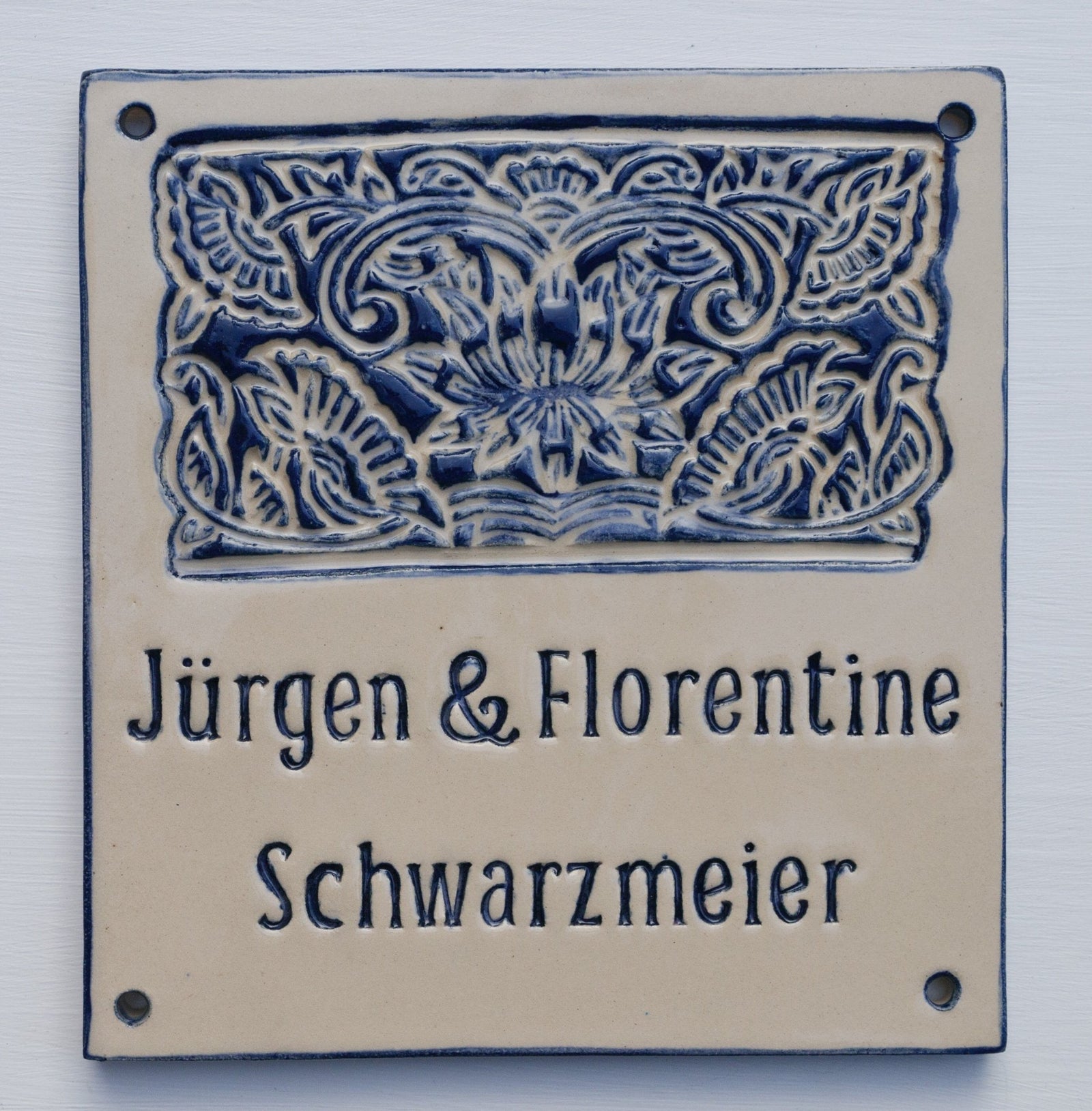 Beiges Keramik-Türschild mit dunkelblauem Lotus-Muster und Aufschrift Jürgen & Florentine Schwarzmeier