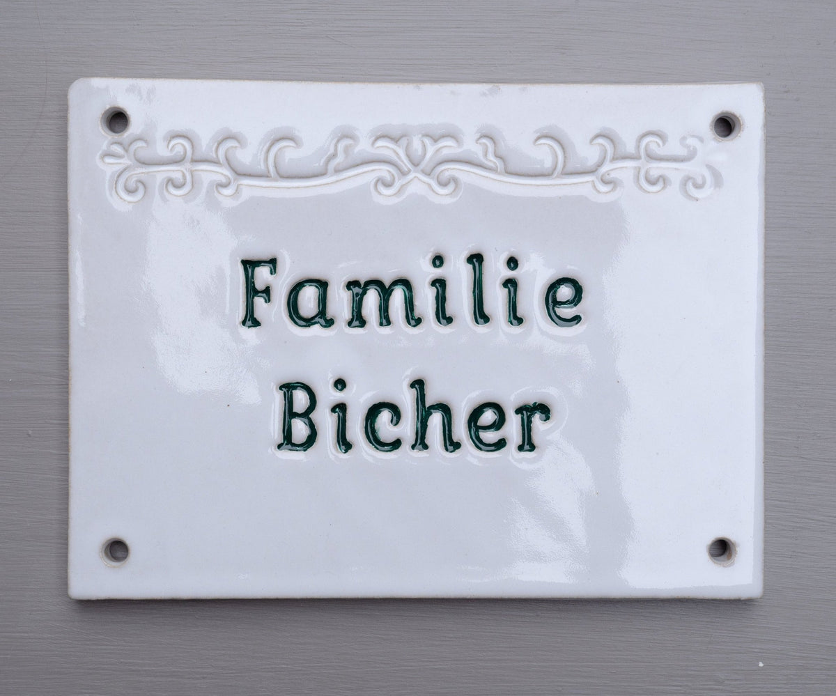 Weißes glänzendes Keramik-Namensschild mit grüner Gravur Familie Bicher