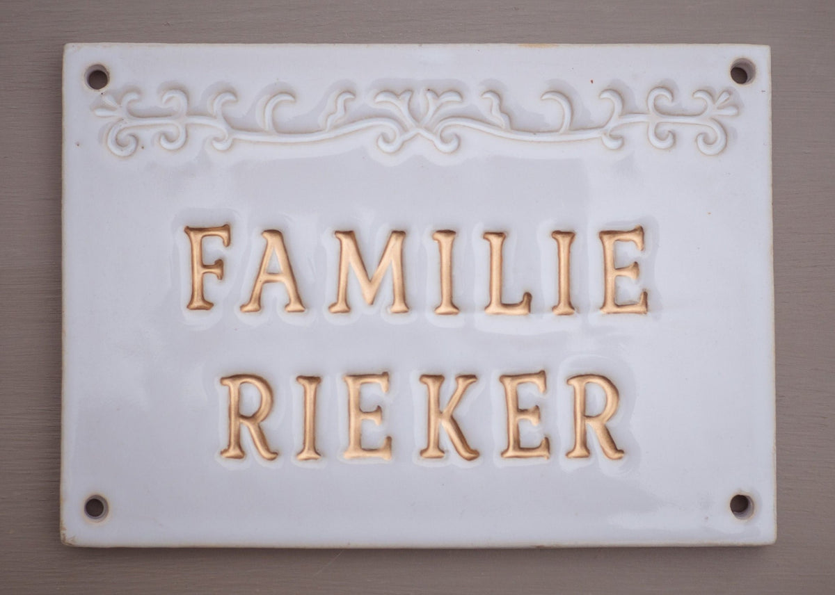 Glänzendes weißes Keramik-Hausschild mit goldener Schrift Familie Rieker